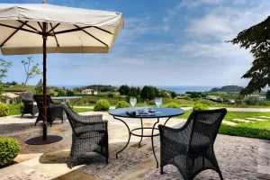 Hotel Iturregi - chairs table with two wine glasses and a parasol