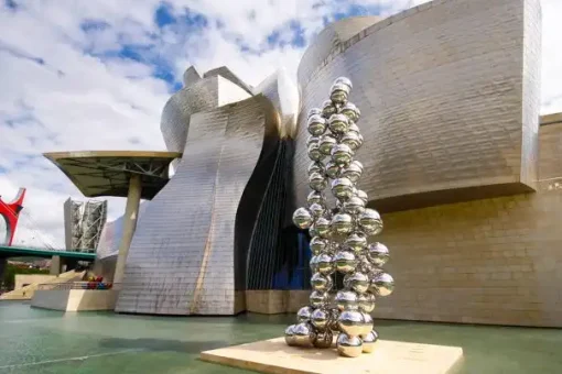 exterior of the Guggenheim Museum with a sculpture made of silver balls in the shape of a christmas tree
